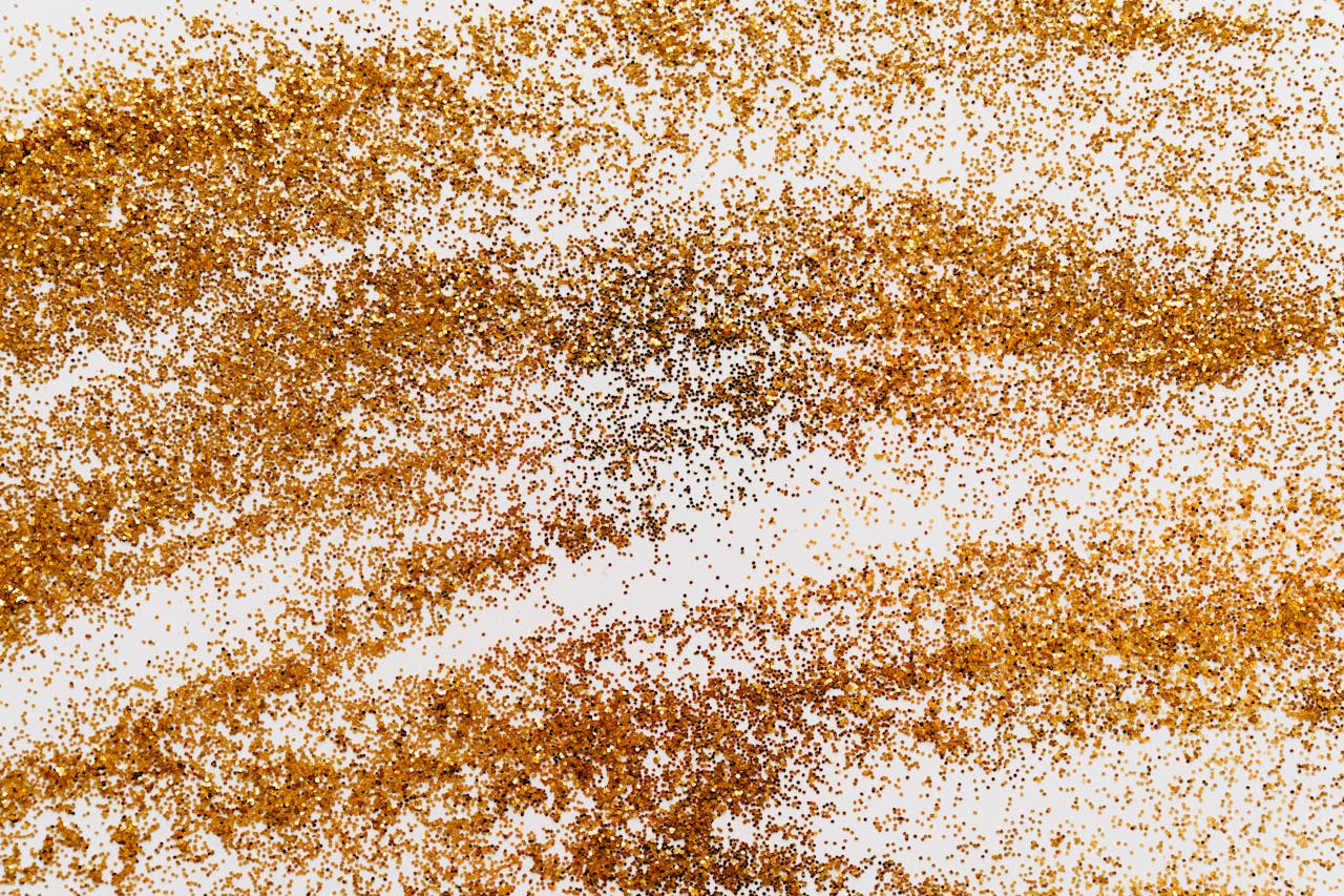 why-choose-us A shimmering abstract pattern of gold glitter scattered on a white surface for decoration and design.